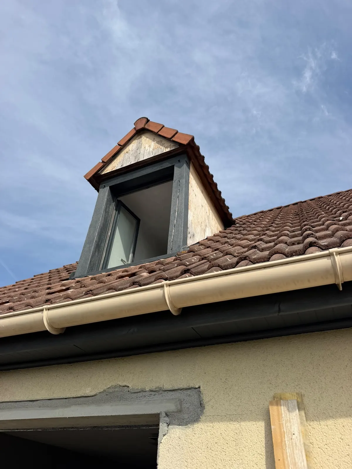 Lucarne de toit avant rénovation à Rouen : habillage bois dégradé et fronton écaillé