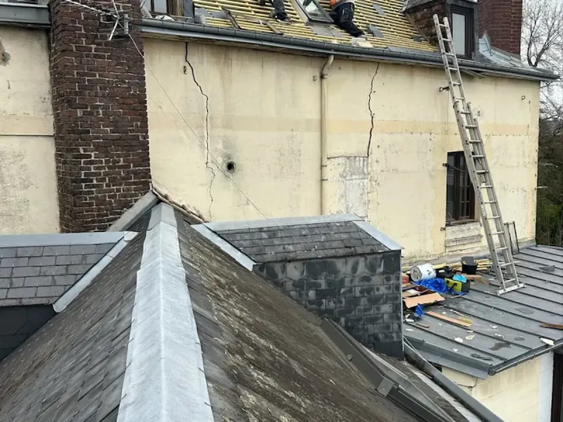 Chantier de couverture zinc et ardoise sur un immeuble de Rouen, liteaunage en cours et échelle contre la façade